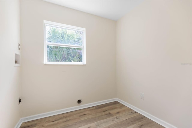 clothes washing area with hookup for an electric dryer and light hardwood / wood-style flooring