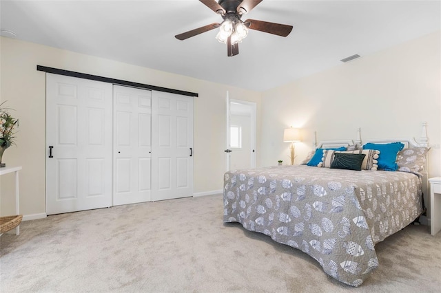 bedroom featuring ceiling fan, a closet, and light colored carpet