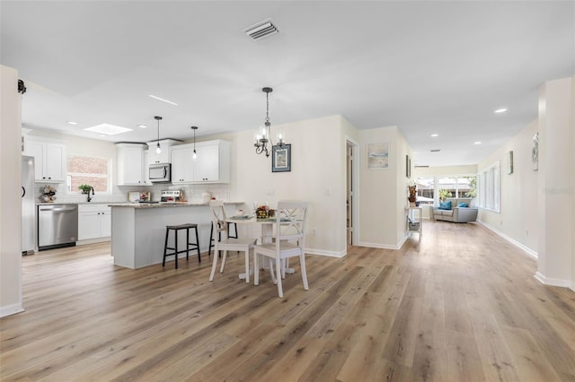 dining room featuring an inviting chandelier and light hardwood / wood-style flooring