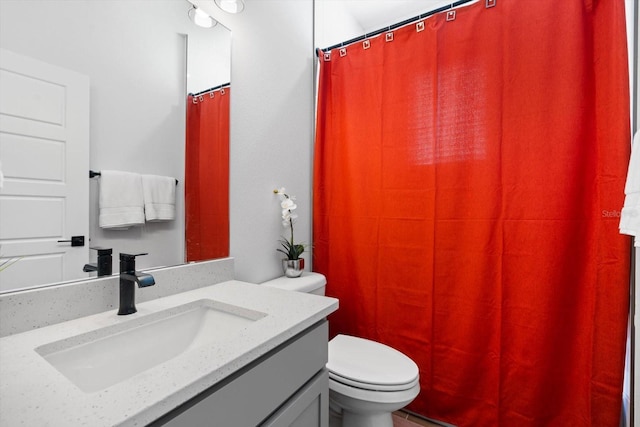 bathroom with vanity, toilet, and walk in shower