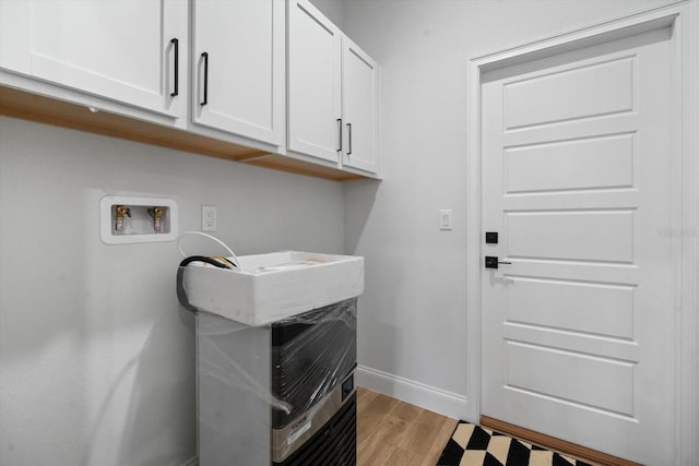 laundry area featuring cabinets, washer hookup, and light wood-type flooring