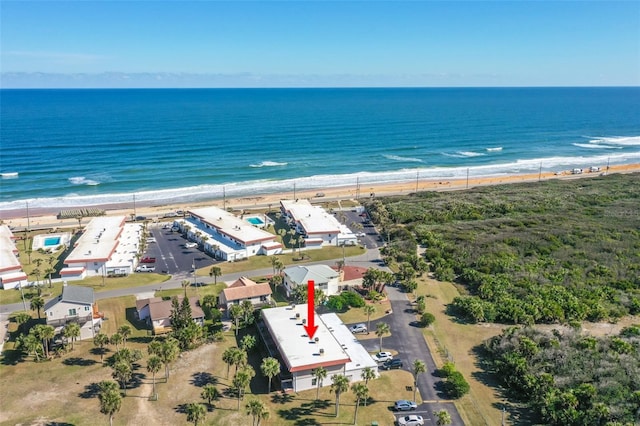 drone / aerial view with a water view and a beach view