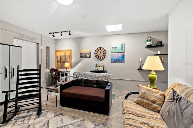 living room with ceiling fan and a skylight