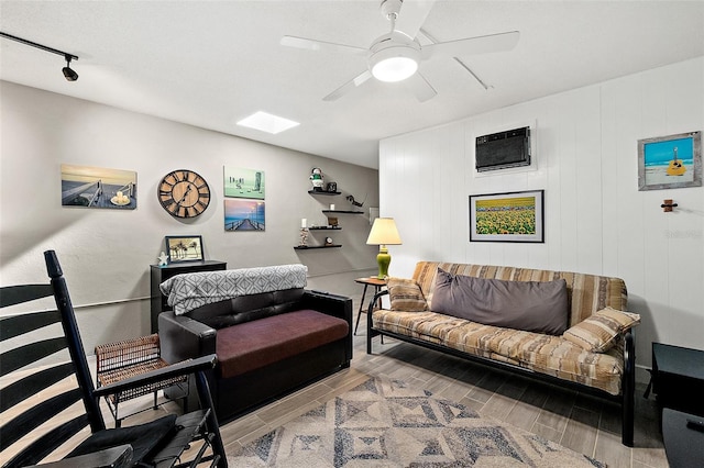 living room featuring wooden walls, ceiling fan, track lighting, and a wall mounted AC