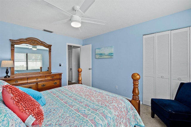 bedroom featuring carpet, ceiling fan, a textured ceiling, and a closet