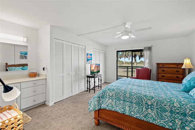 bedroom featuring ceiling fan, light carpet, access to outside, and two closets