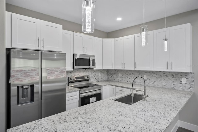 kitchen with white cabinetry, sink, stainless steel appliances, tasteful backsplash, and pendant lighting