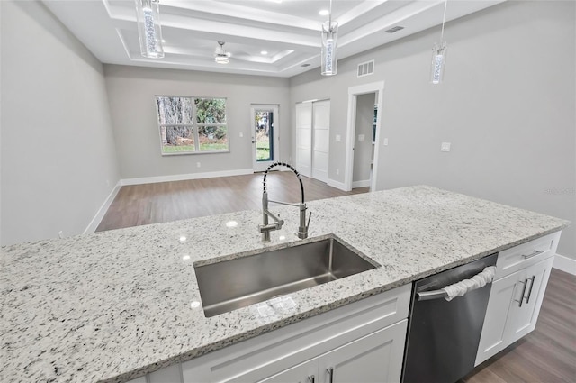 kitchen featuring white cabinetry, dishwasher, sink, decorative light fixtures, and a tray ceiling