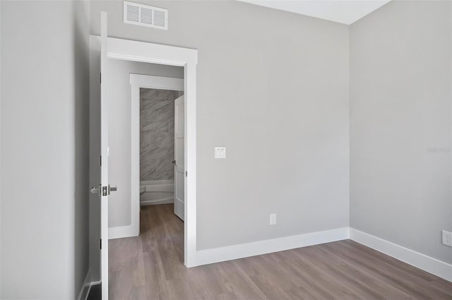 unfurnished room with hardwood / wood-style flooring