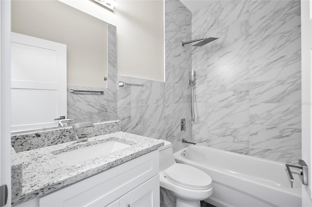 full bathroom featuring toilet, vanity, tile walls, and tiled shower / bath