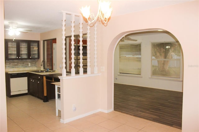 interior space featuring white dishwasher, backsplash, light tile patterned floors, and sink