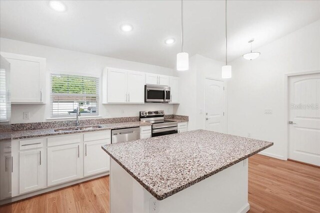 kitchen with white cabinetry, sink, a center island, and stainless steel appliances