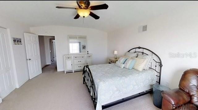 bedroom with ceiling fan, light colored carpet, and vaulted ceiling