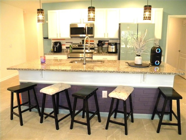 kitchen with a spacious island, white cabinets, and stainless steel appliances