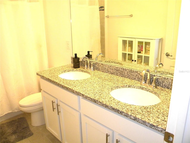bathroom featuring tile patterned flooring, vanity, and toilet