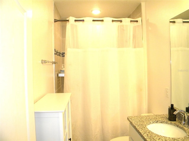 bathroom featuring vanity, toilet, and walk in shower