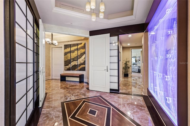 interior space with a tray ceiling and a chandelier