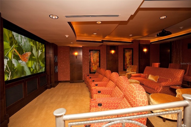 carpeted cinema room with a tray ceiling