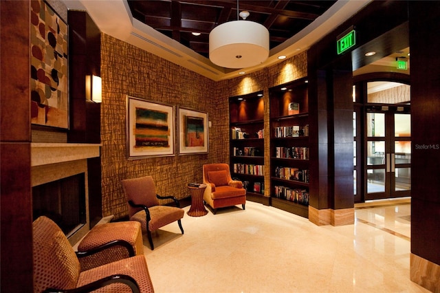 living area with coffered ceiling and a high ceiling