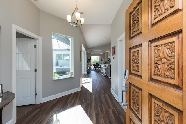 entryway with a notable chandelier, dark hardwood / wood-style flooring, and vaulted ceiling