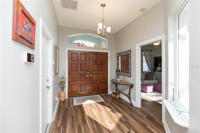 entrance foyer featuring dark hardwood / wood-style floors, plenty of natural light, and an inviting chandelier