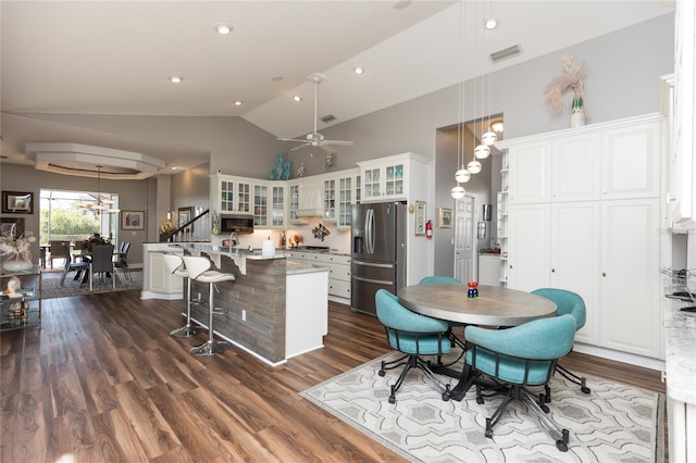 kitchen with white cabinets, decorative light fixtures, stainless steel appliances, and a kitchen island