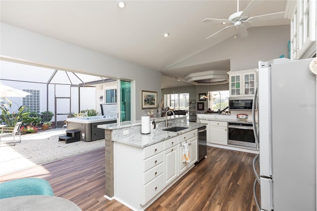 kitchen with white cabinetry, sink, white refrigerator, oven, and a center island with sink