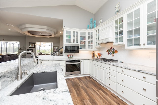 kitchen featuring light stone countertops, sink, stainless steel appliances, premium range hood, and white cabinets