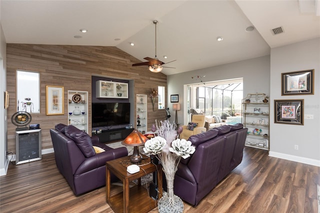 living room with dark hardwood / wood-style floors, ceiling fan, lofted ceiling, and wooden walls