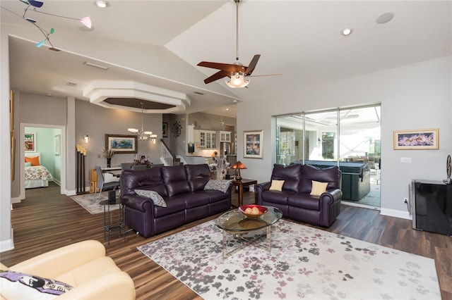 living room with ceiling fan with notable chandelier and dark hardwood / wood-style floors