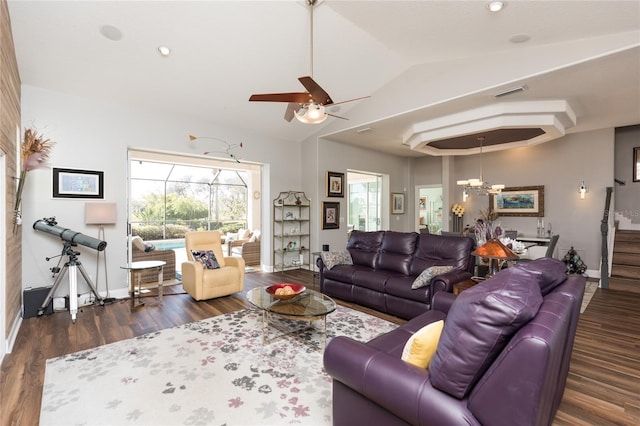 living room with lofted ceiling, dark hardwood / wood-style flooring, and ceiling fan with notable chandelier