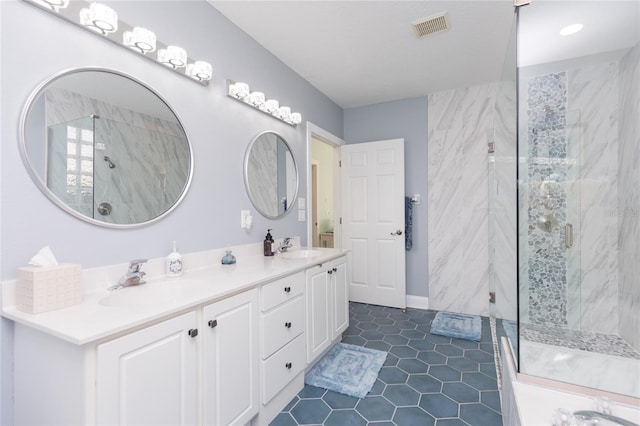 bathroom featuring a shower with door and vanity