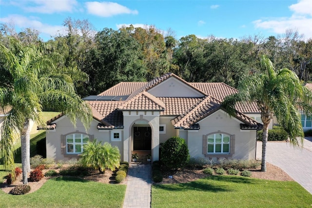 mediterranean / spanish-style home with a front yard