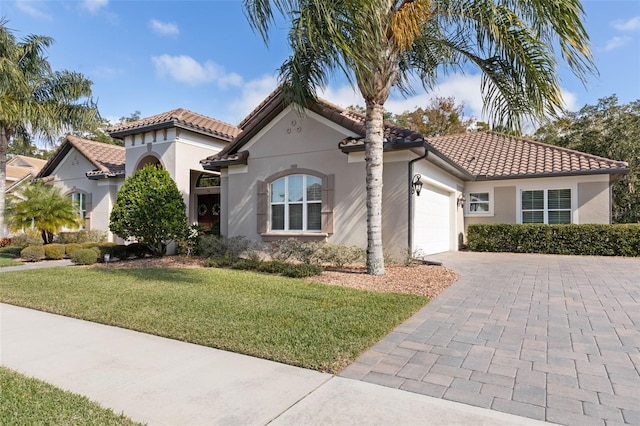 mediterranean / spanish house with a front yard and a garage