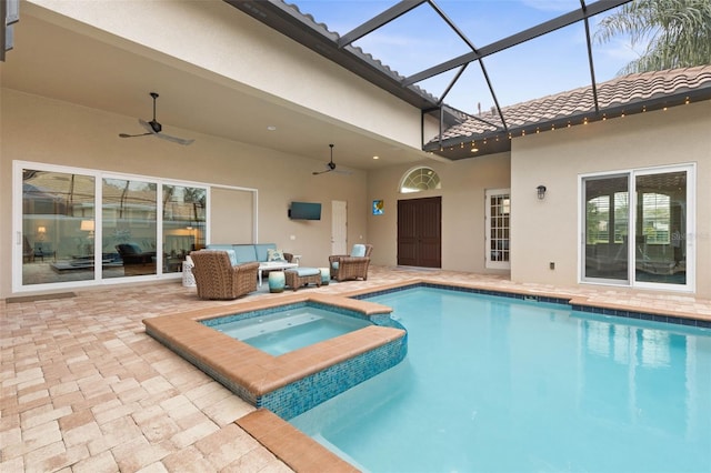 view of swimming pool with an in ground hot tub, a lanai, outdoor lounge area, ceiling fan, and a patio area