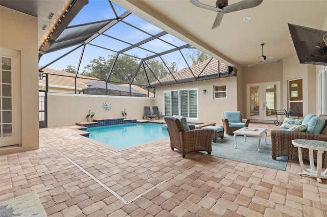 view of pool with outdoor lounge area, ceiling fan, french doors, a lanai, and a patio area