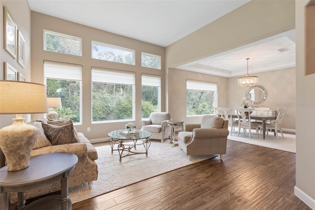 living room with dark wood-type flooring and a notable chandelier