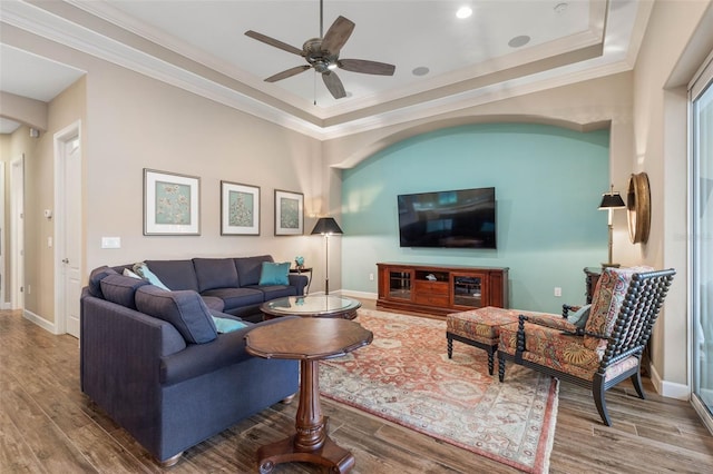 living room with hardwood / wood-style floors, ceiling fan, and crown molding