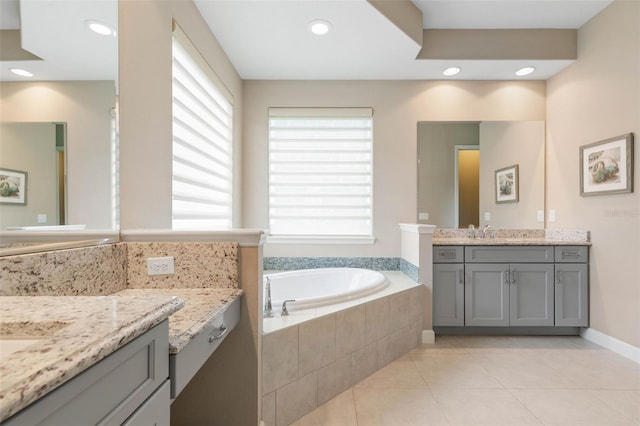 bathroom featuring tile patterned flooring, vanity, and tiled tub