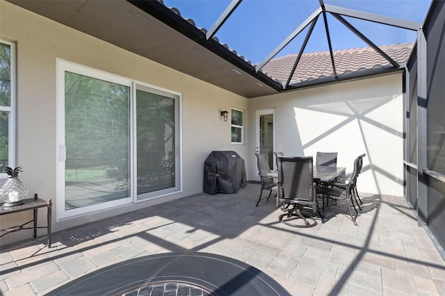 view of patio with glass enclosure and grilling area