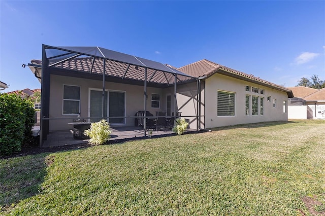 rear view of property featuring glass enclosure, a patio area, and a yard