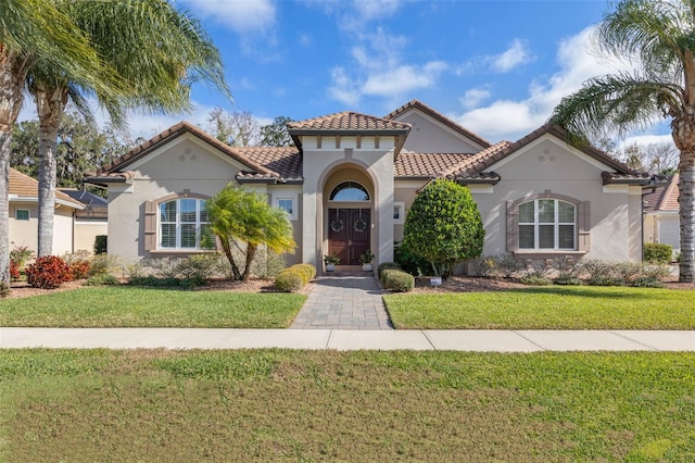 mediterranean / spanish home featuring a front lawn