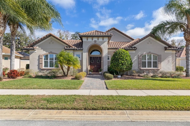 mediterranean / spanish house featuring a front lawn