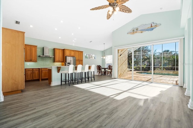 living room featuring dark hardwood / wood-style floors, high vaulted ceiling, and ceiling fan