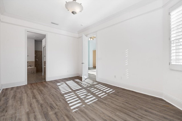 spare room with crown molding and dark wood-type flooring