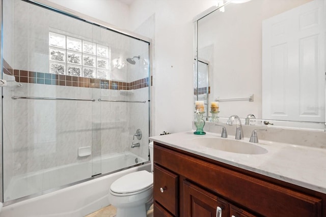 full bathroom with vanity, toilet, and bath / shower combo with glass door