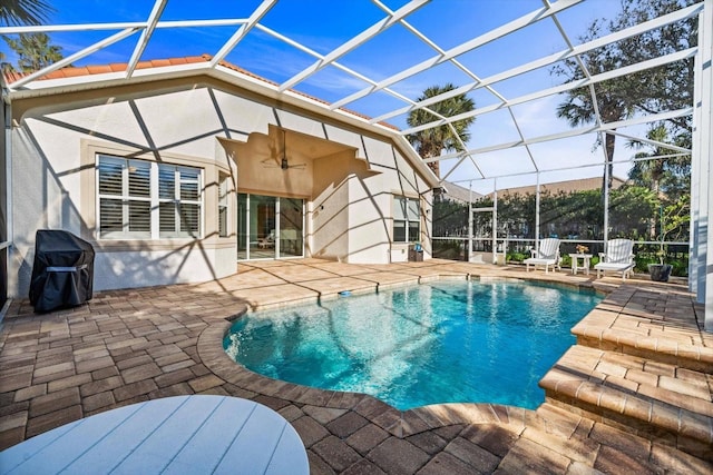 view of swimming pool with a lanai, area for grilling, and a patio