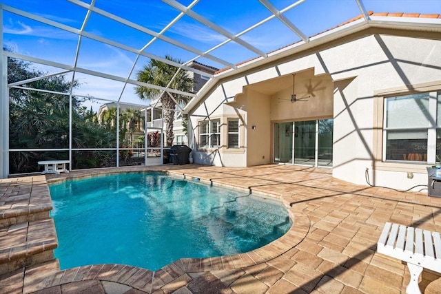 view of swimming pool featuring ceiling fan, a grill, a patio area, and glass enclosure