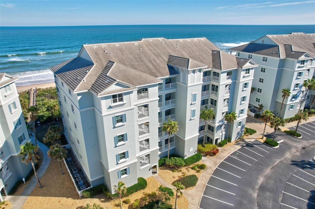 drone / aerial view featuring a water view and a beach view