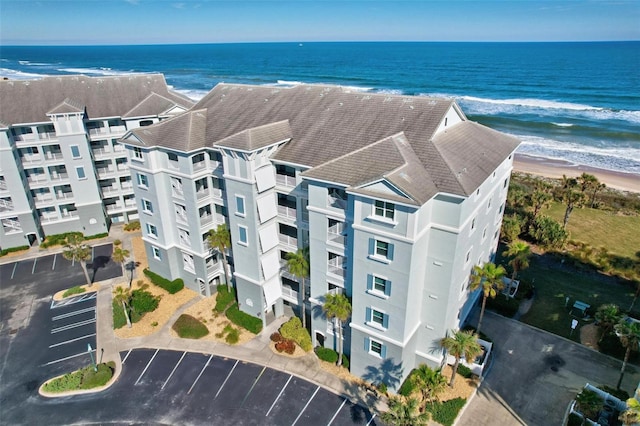 bird's eye view featuring a water view and a beach view